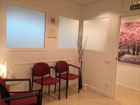 Clínica Dental Reyes Flamarique sala de espera con sillas rojas
